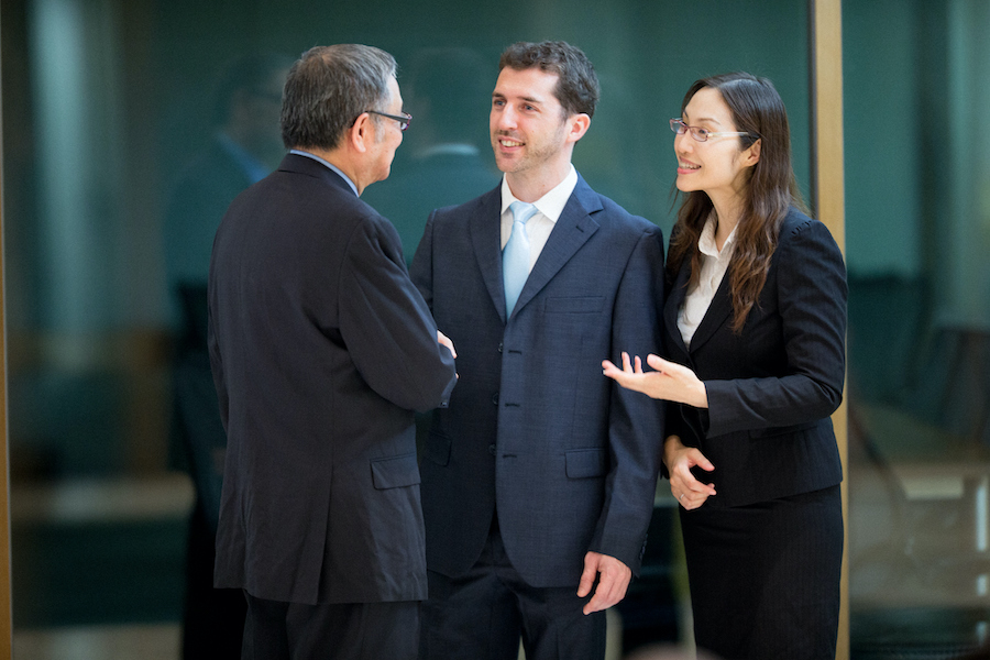 Caucasian businessman with his interpreter speaking with Asian businessman