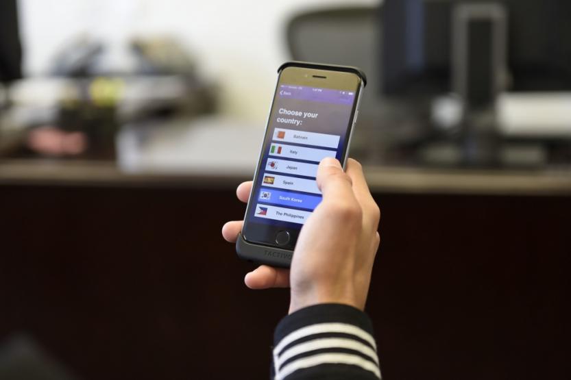 Hand holding a phone showing the LREC Navy Global Deployer app