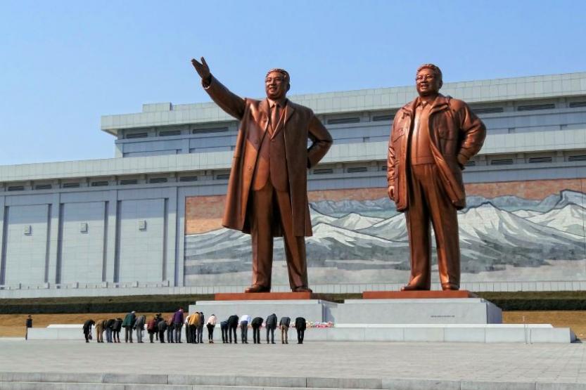 Visitors bowing in a show of respect for North Korean leaders Kim Il-sung and Kim Jong-il on Mansudae (Mansu Hill) in Pyongyang, North Korea.