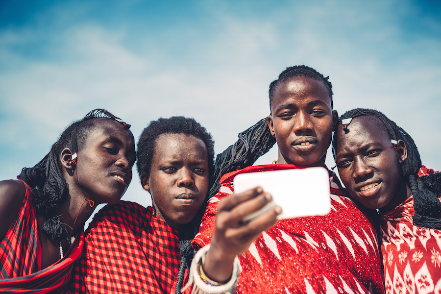 Four Maasai men looking at a cell phone in Kenya
