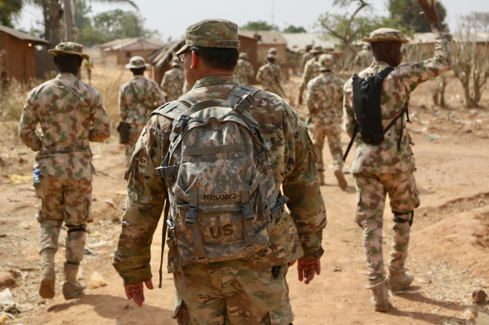 U.S. Army Soldiers walking with Nigerian Army Soldiers in a remote military compound four hours north of the capital in Jaji.