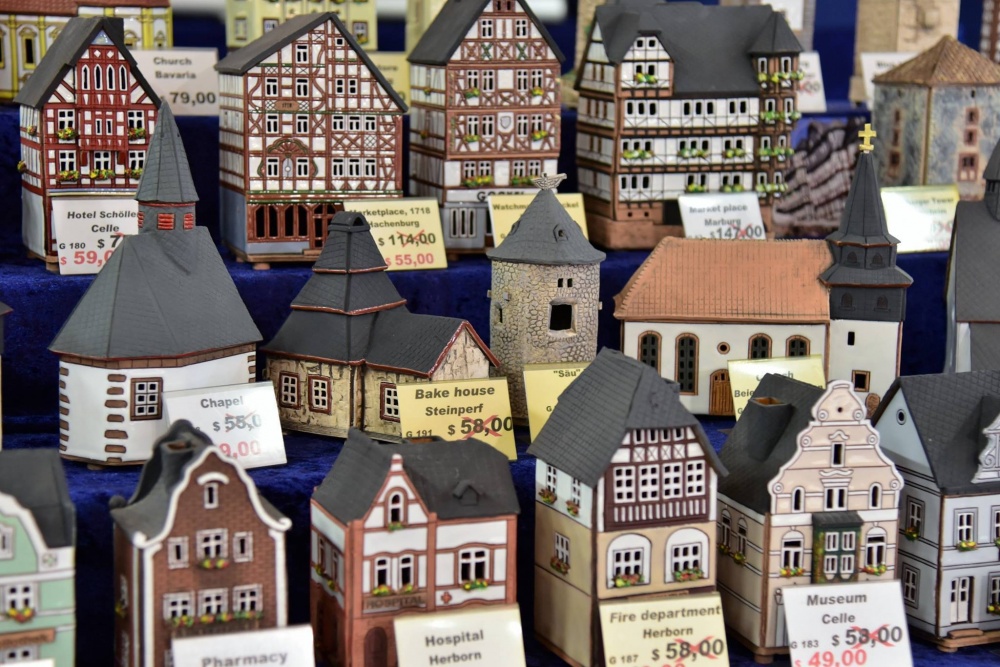 Image of artisan-crafted miniature buildings on sale with prices marked at the  U.S. Army Garrison Rheinland-Pfalz Holiday Bazaar