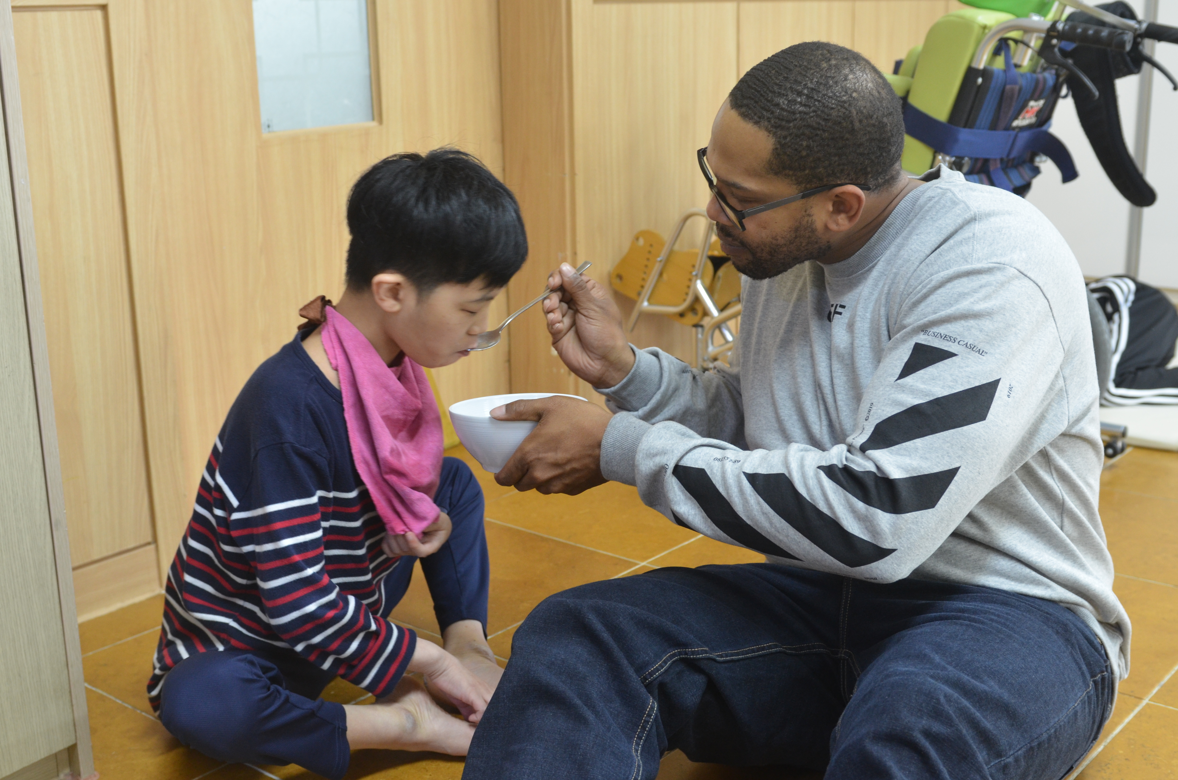 A soldier feeds a special needs resident in an orphanage.