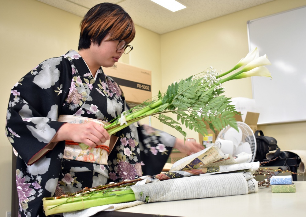 A woman prepares flowers for a class on the Japanese art of flower arrangement, or “ikebana.”
