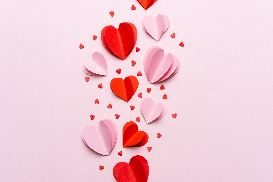 Pink and red paper hearts on a pink background