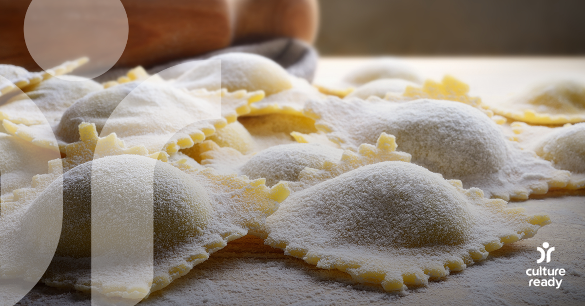 A close up picture of freshly made golden ravioli covered in flour