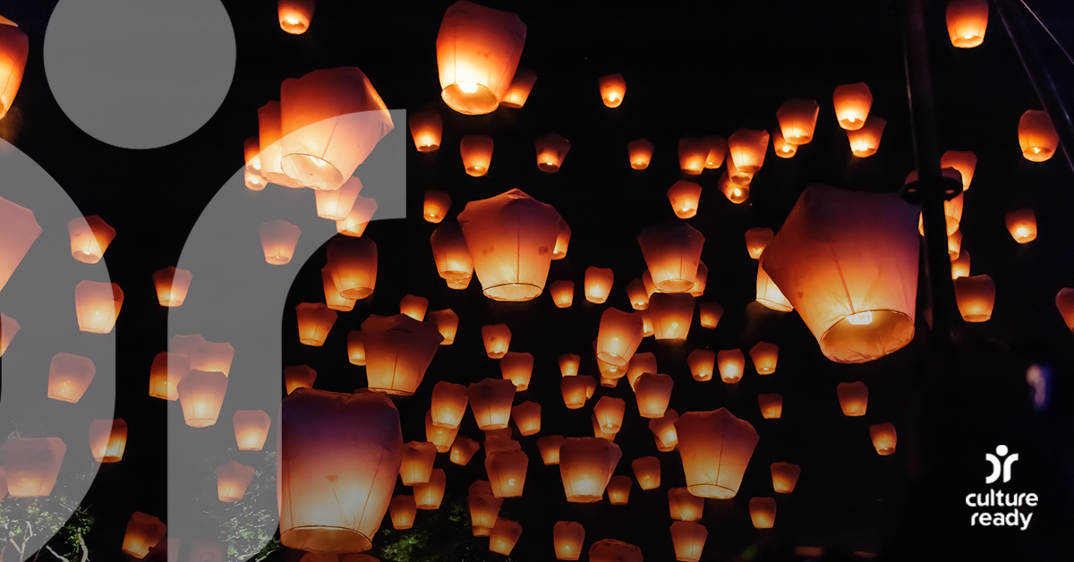 Hundreds of illuminated paper lanterns float in the night sky