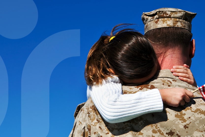 Image of a young girl hugging a servicemember.